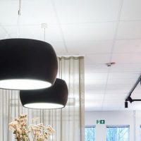 Nedhengt sort rund lampe med opp direkte og indirekte belysning.